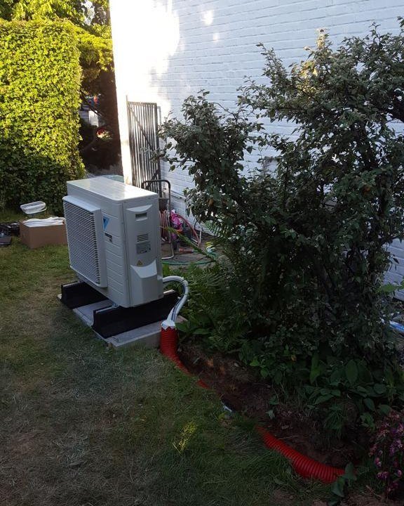 Lucht-waterwarmtepomp geplaatst in de tuin van een eengezinswoning
