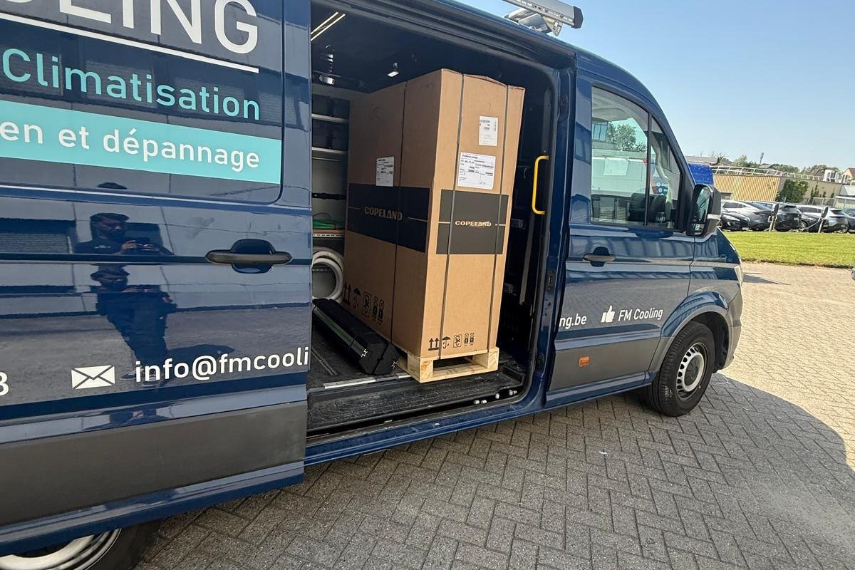Bestelwagen van FM Cooling, geladen met materiaal, voor een werf